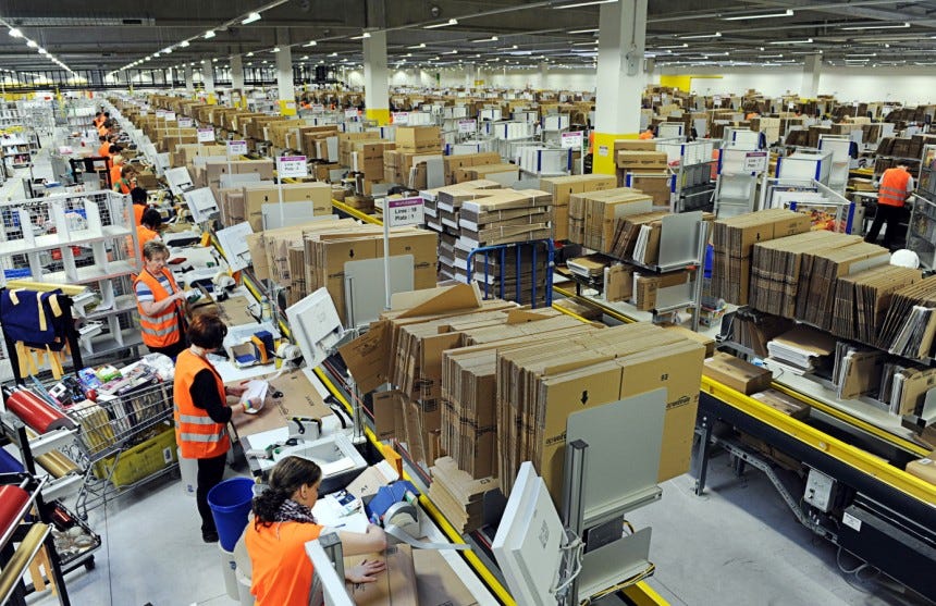 A Bustling Amazon Fulfillment Center With Workers Sorting And Packaging Products For Shipment